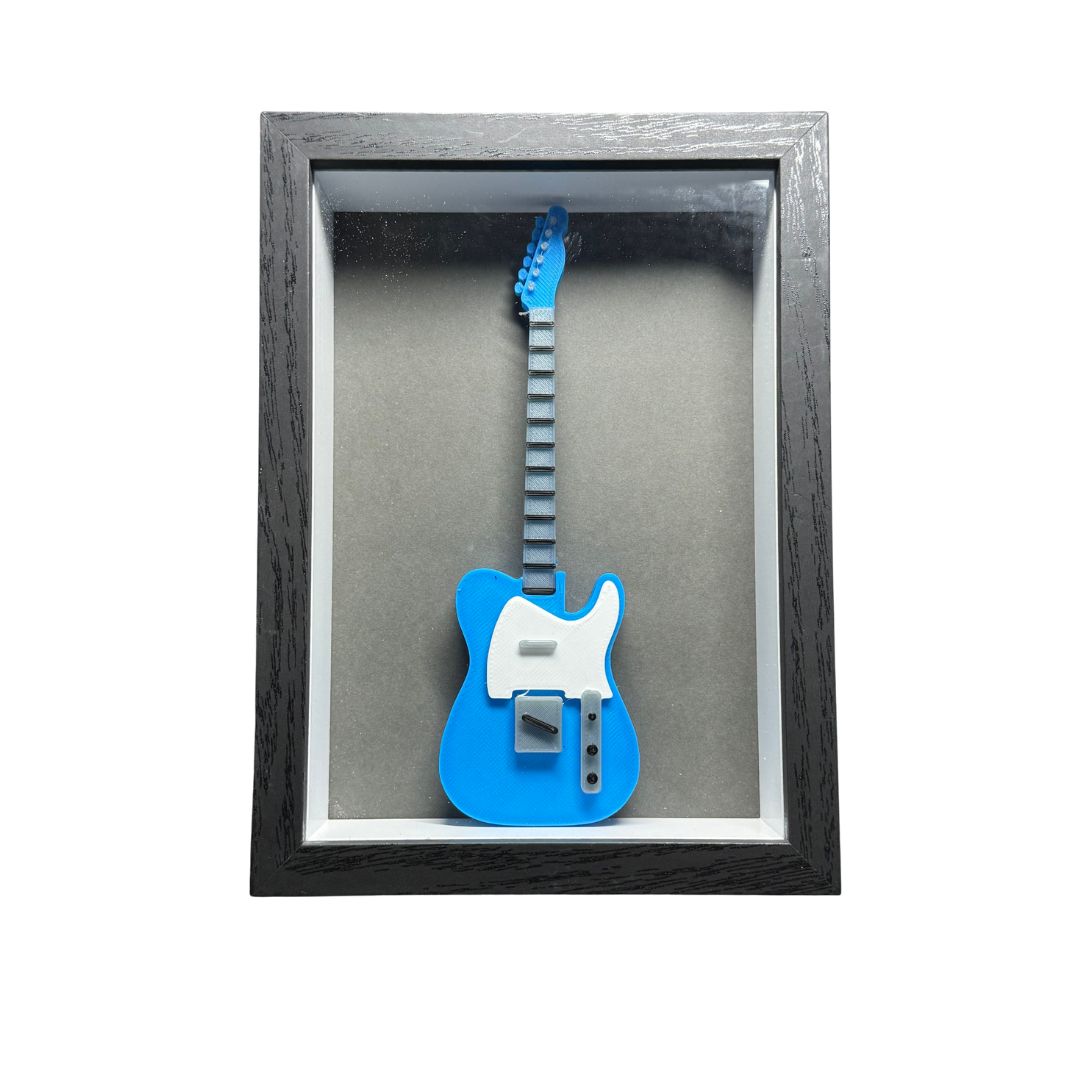 Blue and white guitar model in a black frame on a gray background