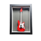Red electric guitar model in a black frame on a white background