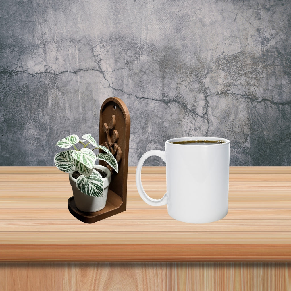 White mug with a plant on a wooden surface against a gray textured wall.